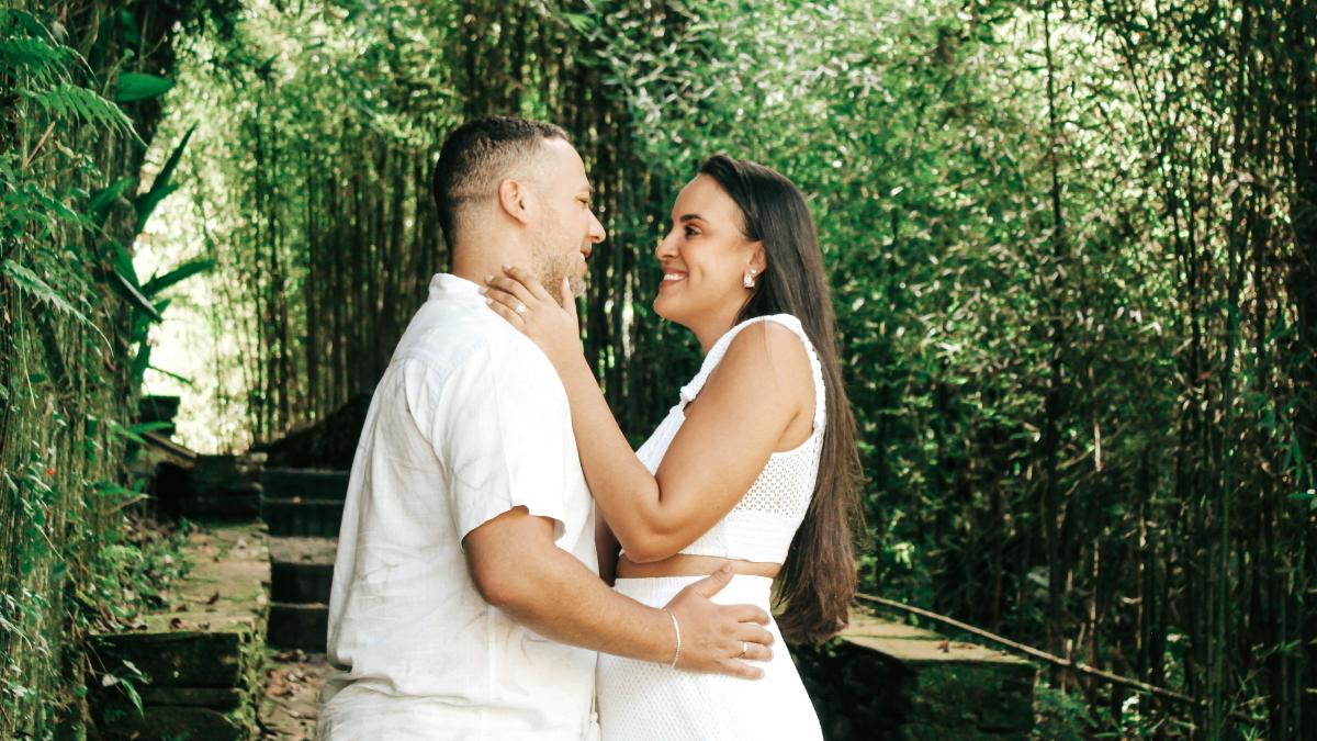 a man and a woman standing in front of bamboo trees