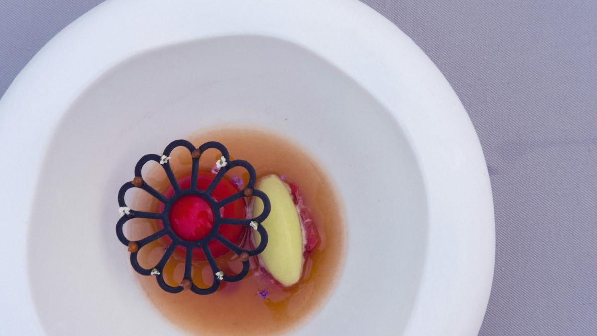 A white bowl with a flower decoration in it