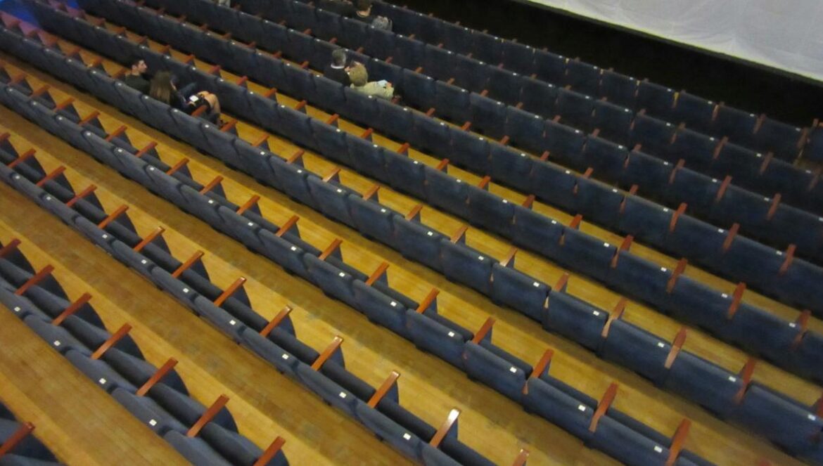 A large auditorium with rows of seats and a projector screen