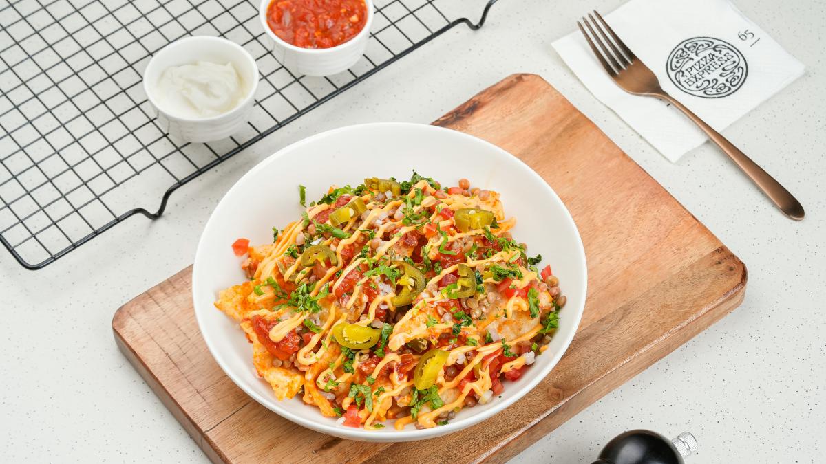 A bowl of food sitting on top of a wooden cutting board