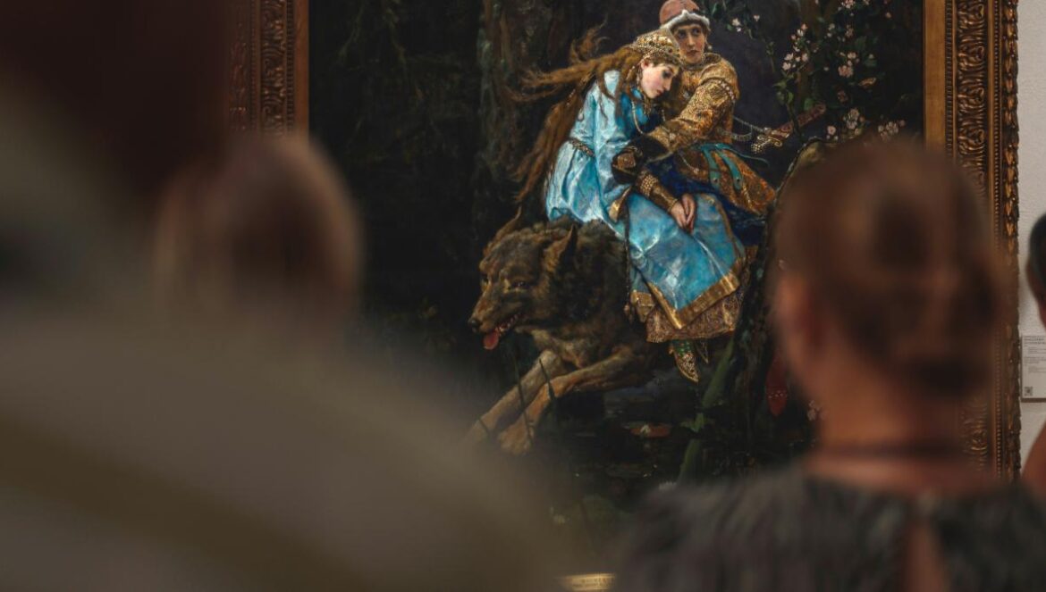 A group of people standing around a painting