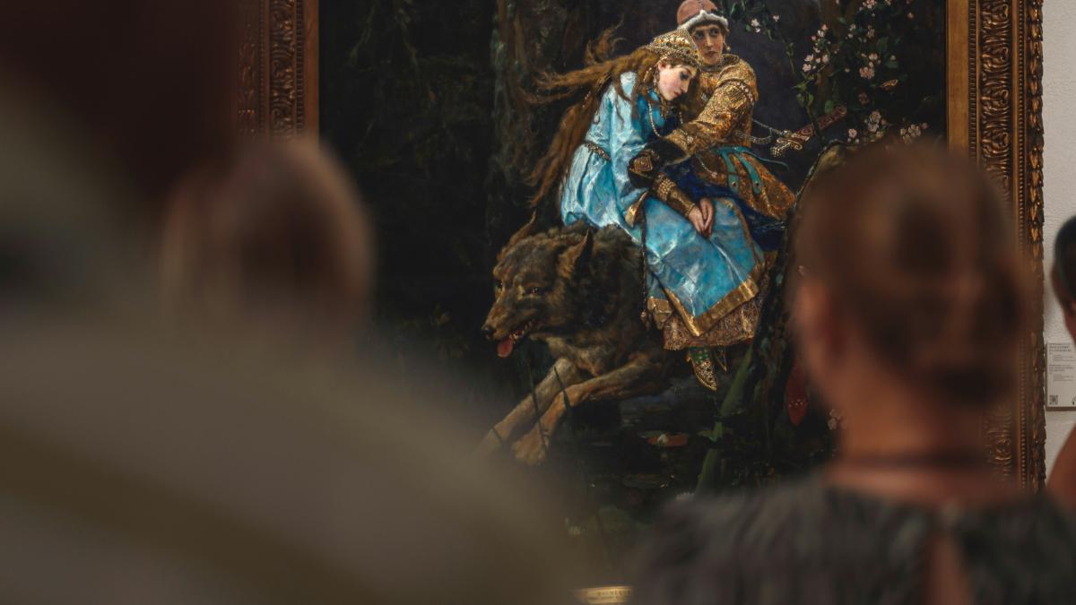 A group of people standing around a painting