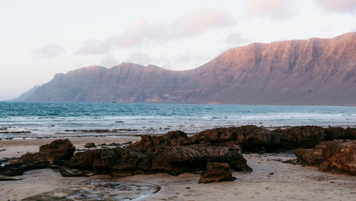 A rocky beach with a mountain in the background