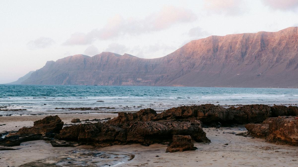 A rocky beach with a mountain in the background