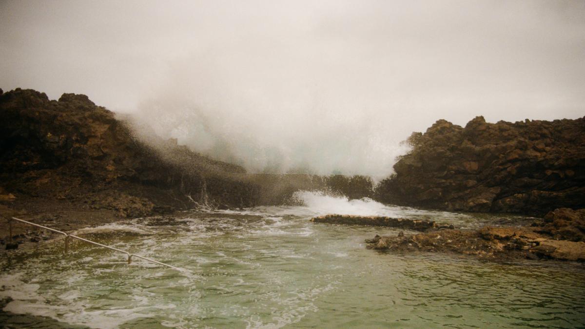 A body of water surrounded by rocks on a cloudy day