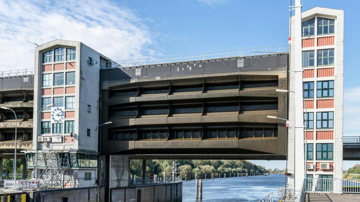 A bridge over a body of water with a building in the background