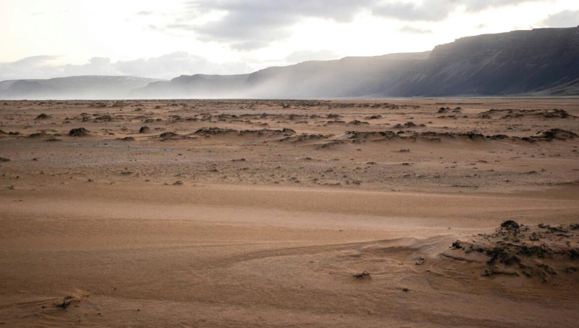 A desert landscape with mountains in the distance