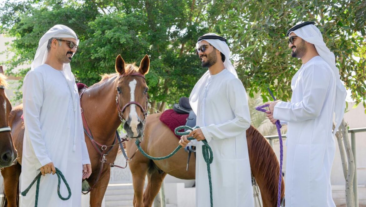 A group of men standing next to a brown horse