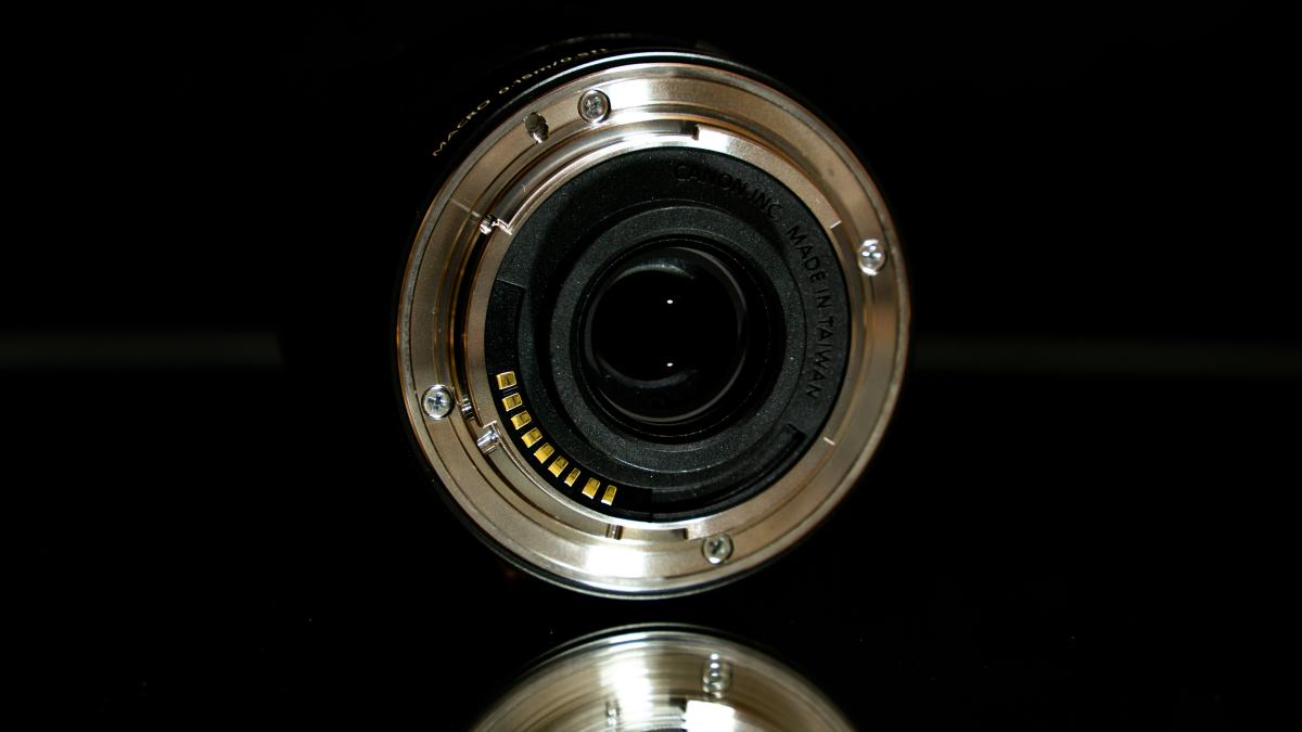 A camera lens sitting on top of a reflective surface