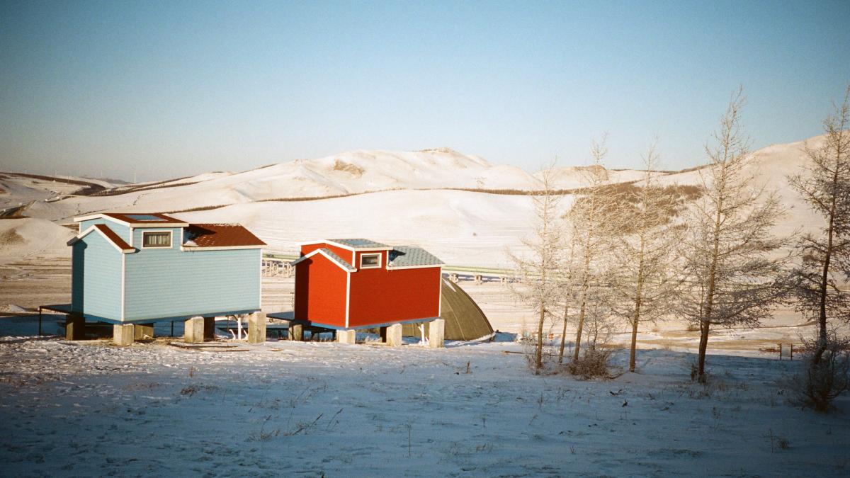 A couple of buildings sitting on top of a snow covered field