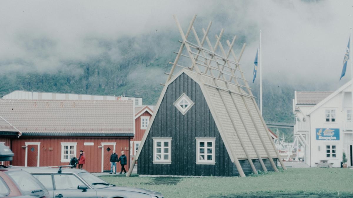 A car is parked in front of a barn
