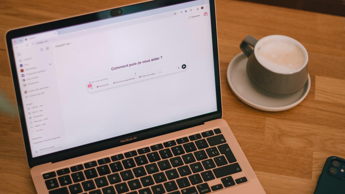 Laptop and coffee on a wooden table.