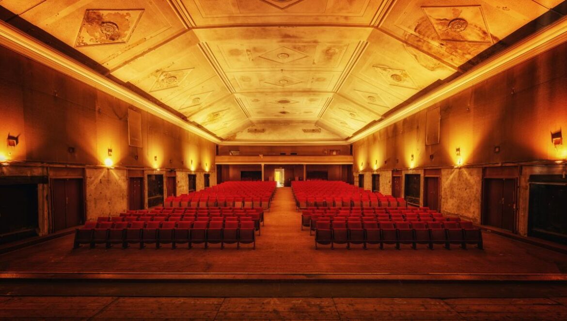 An empty theater room is filled with rows of seats.