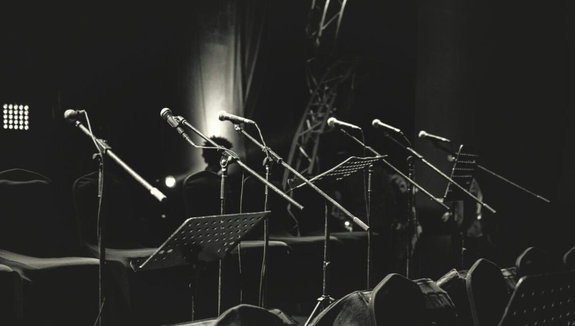 grayscale photo of microphone stands
