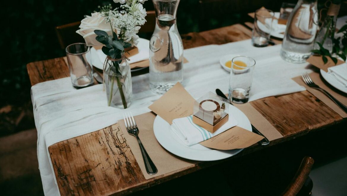 a wooden table topped with plates and glasses
