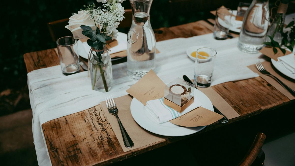 a wooden table topped with plates and glasses