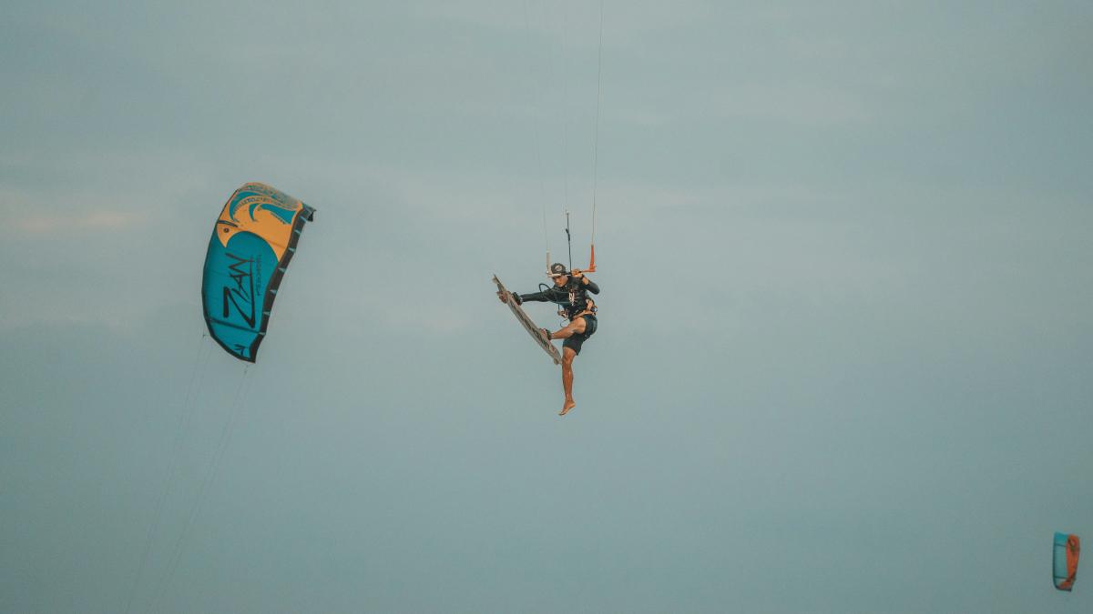 a person is parasailing in the ocean on a cloudy day