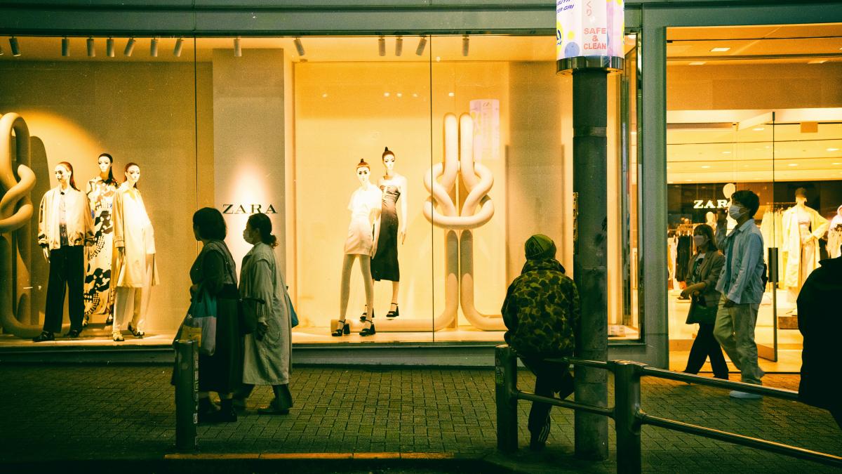 a group of people standing in front of a store window