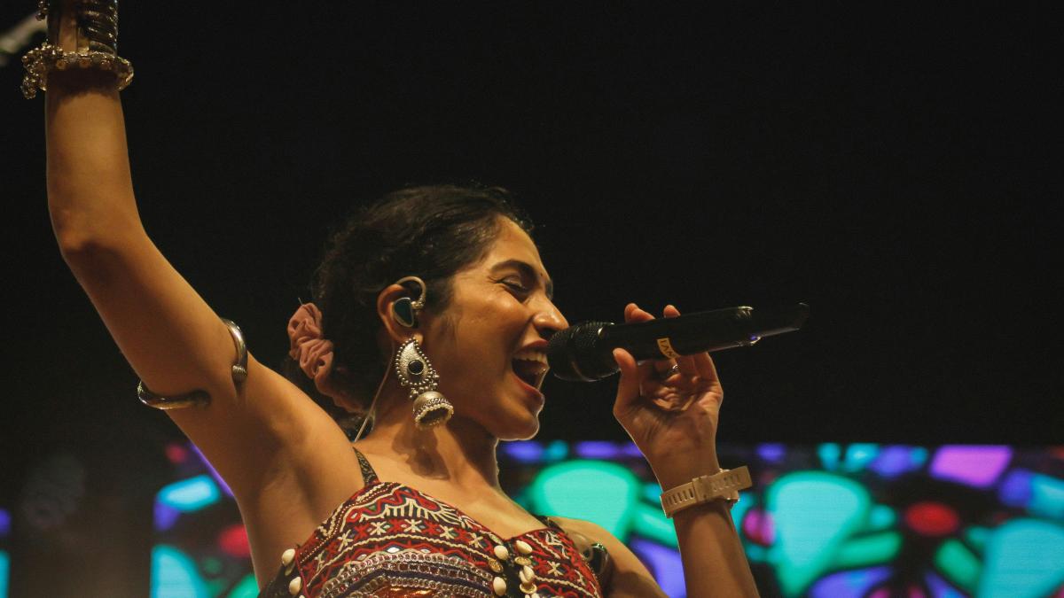 A woman in a dress singing into a microphone
