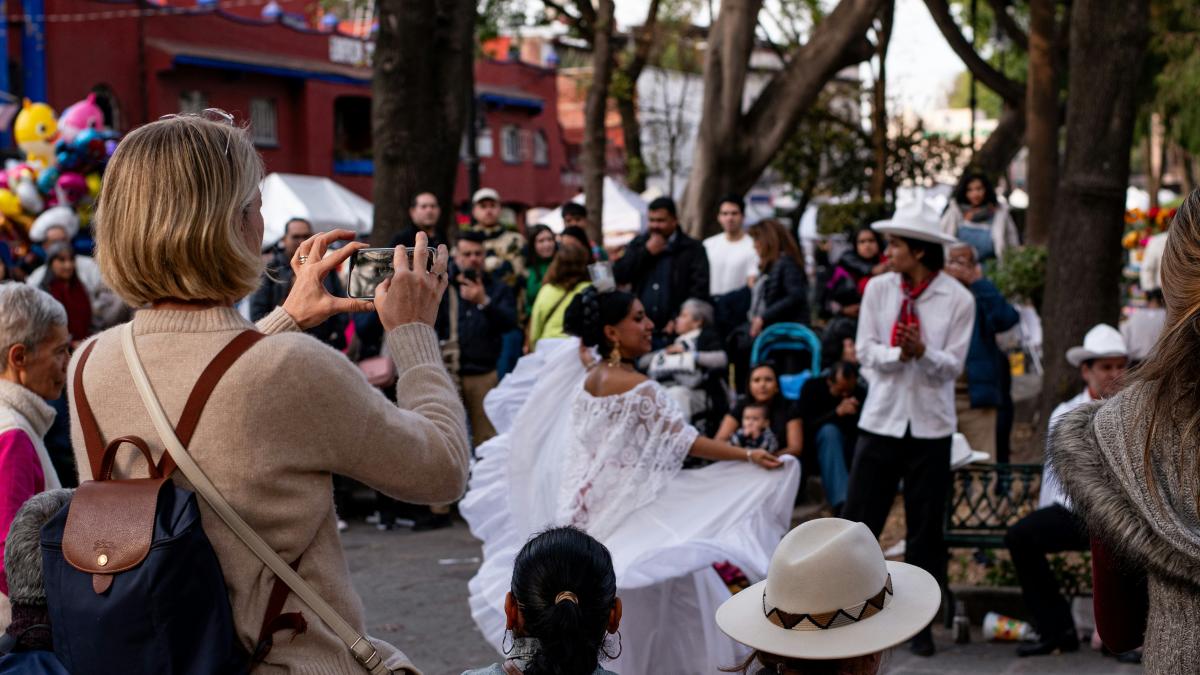 A crowd of people standing around each other