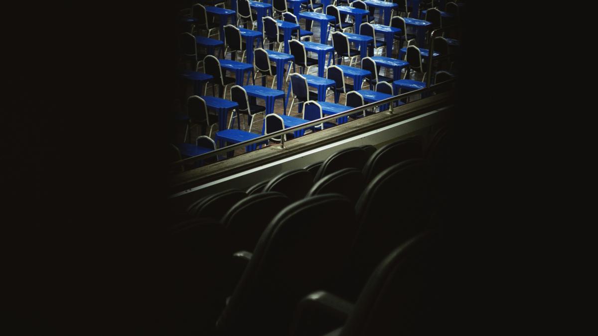 a row of blue chairs in a dark room