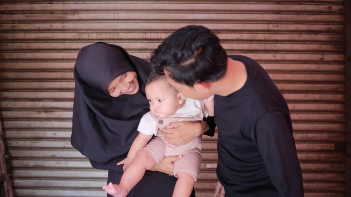 a man and woman holding a baby in their arms