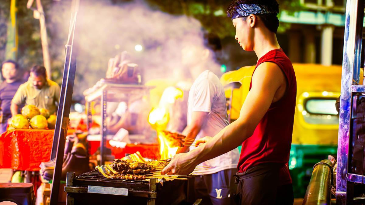 A street vendor is cooking food at night.
