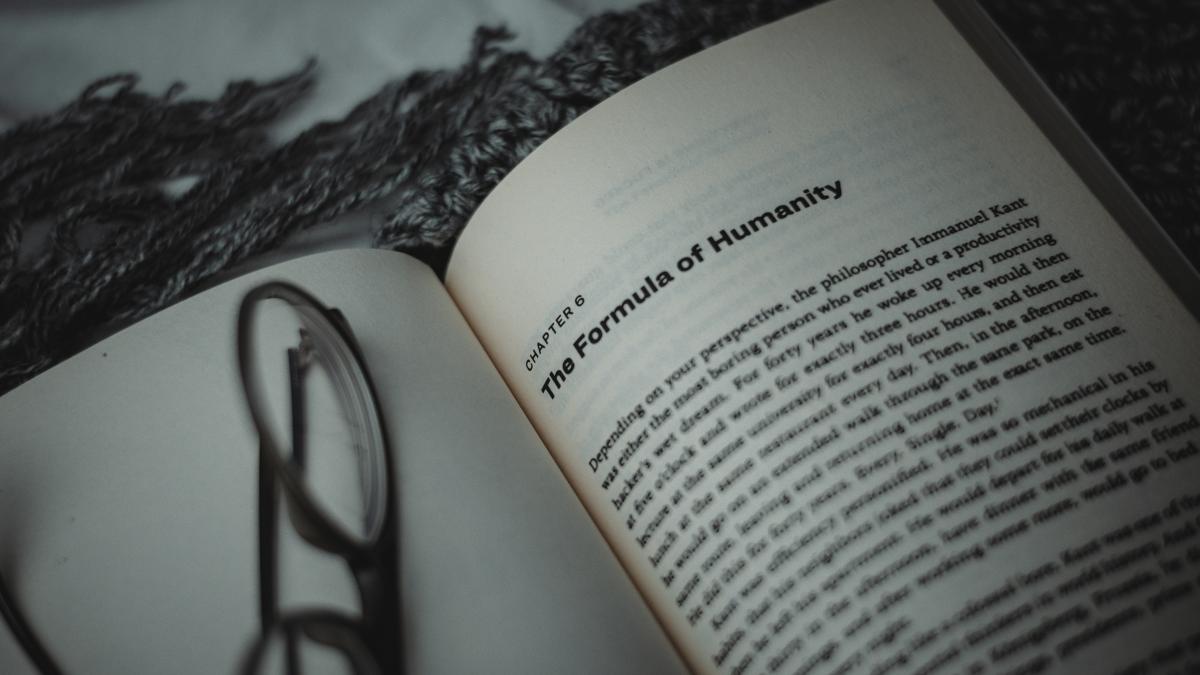 an open book with a pair of glasses on top of it