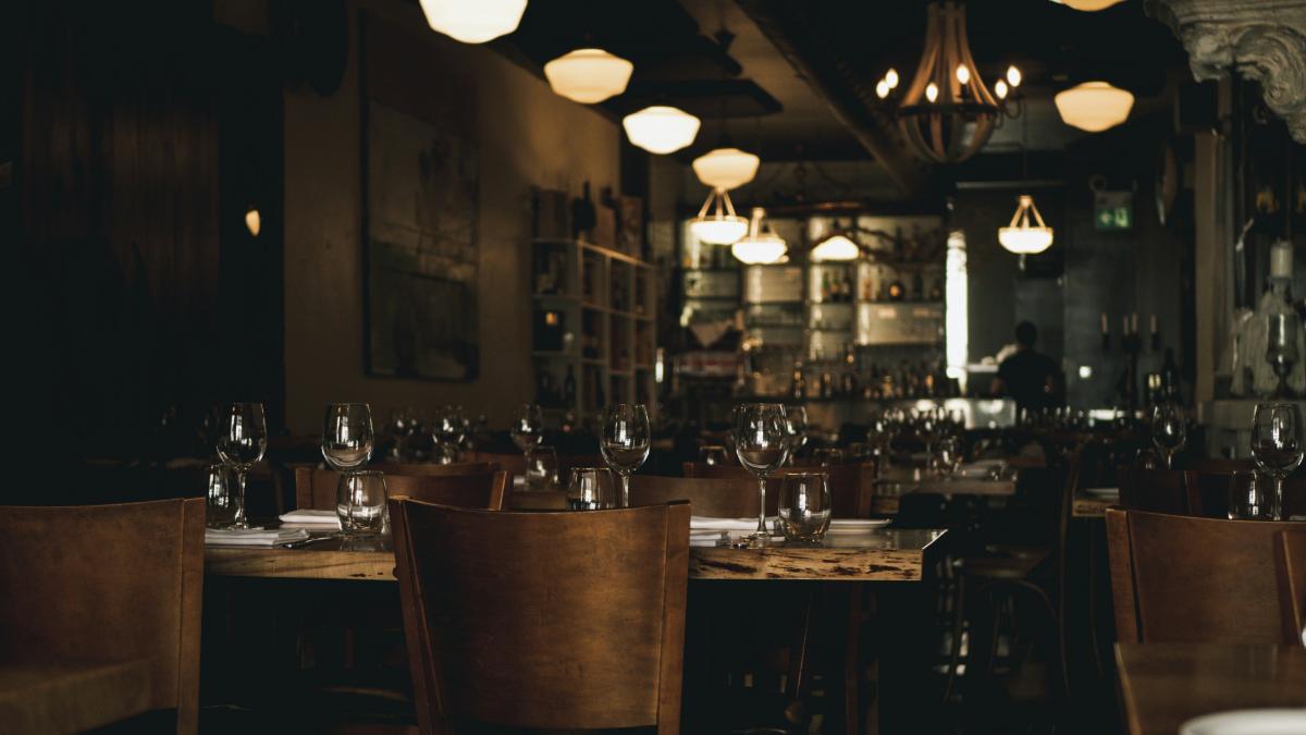 a dimly lit restaurant with wooden tables and chairs