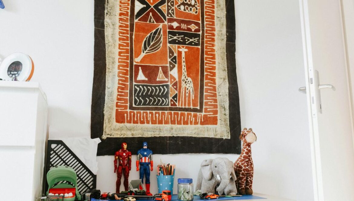 a wooden table topped with toys next to a wall hanging