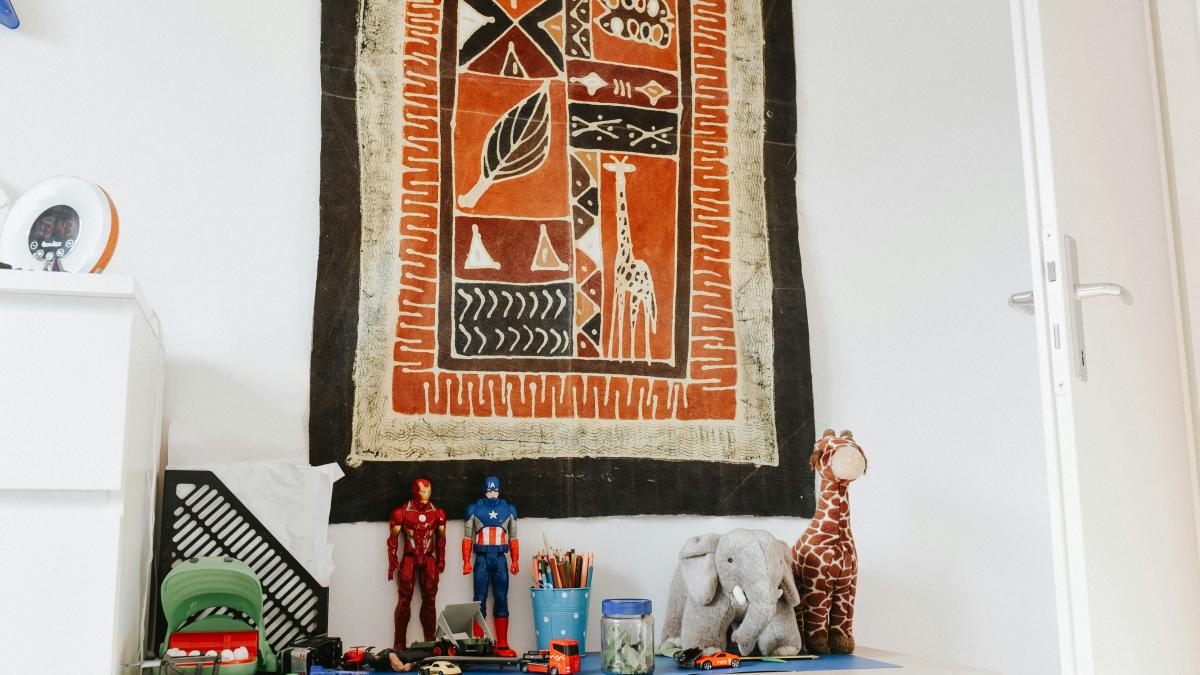 a wooden table topped with toys next to a wall hanging