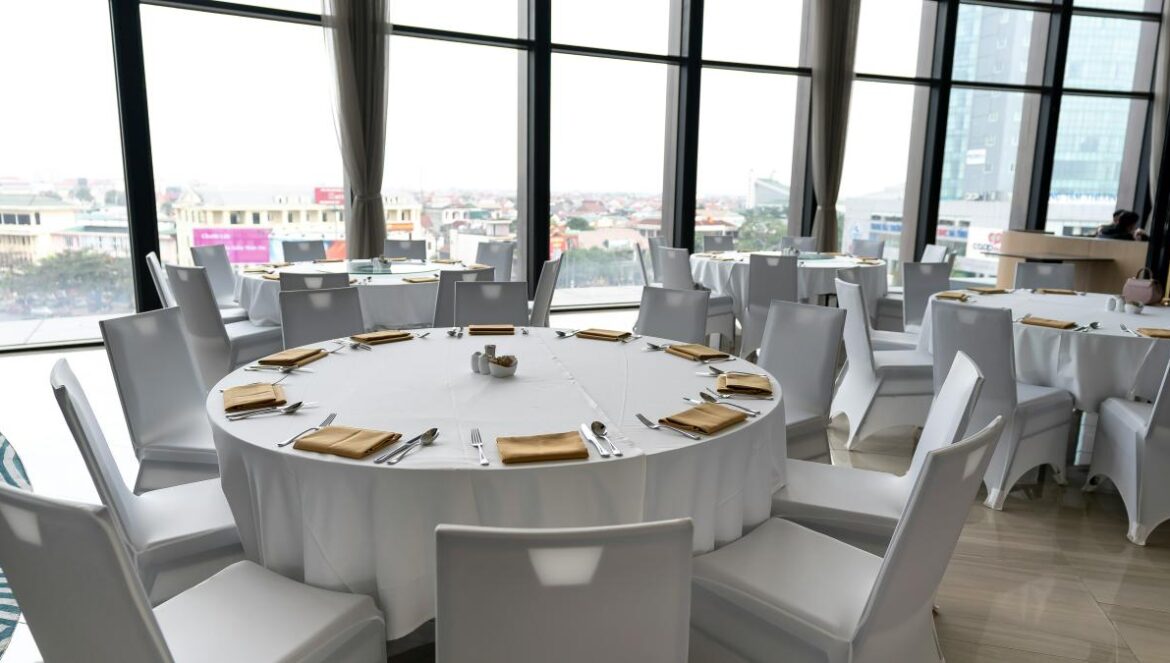 a room filled with lots of white tables and chairs