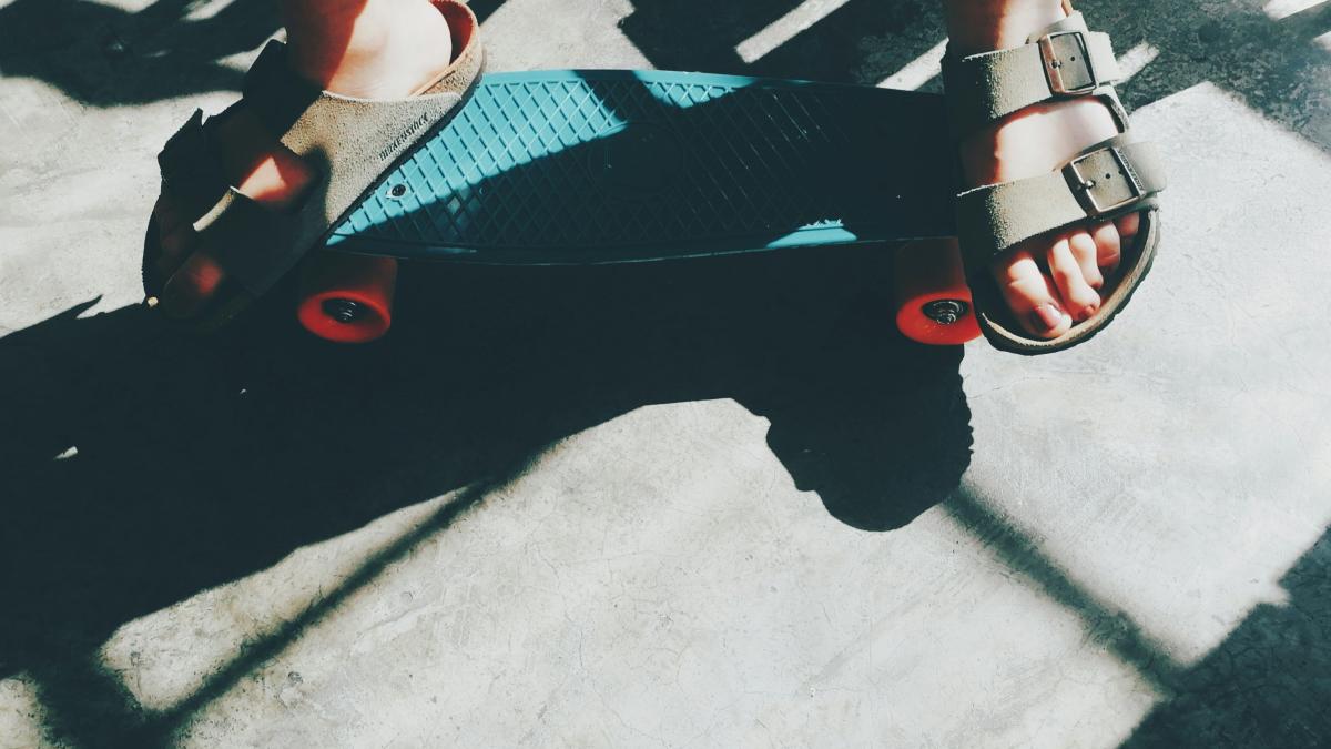 person riding teal cruiser penny board