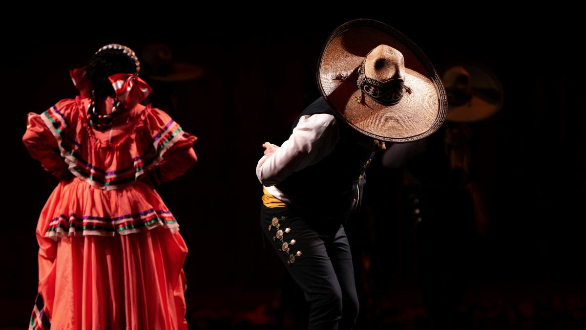 A couple of people that are standing in the dark