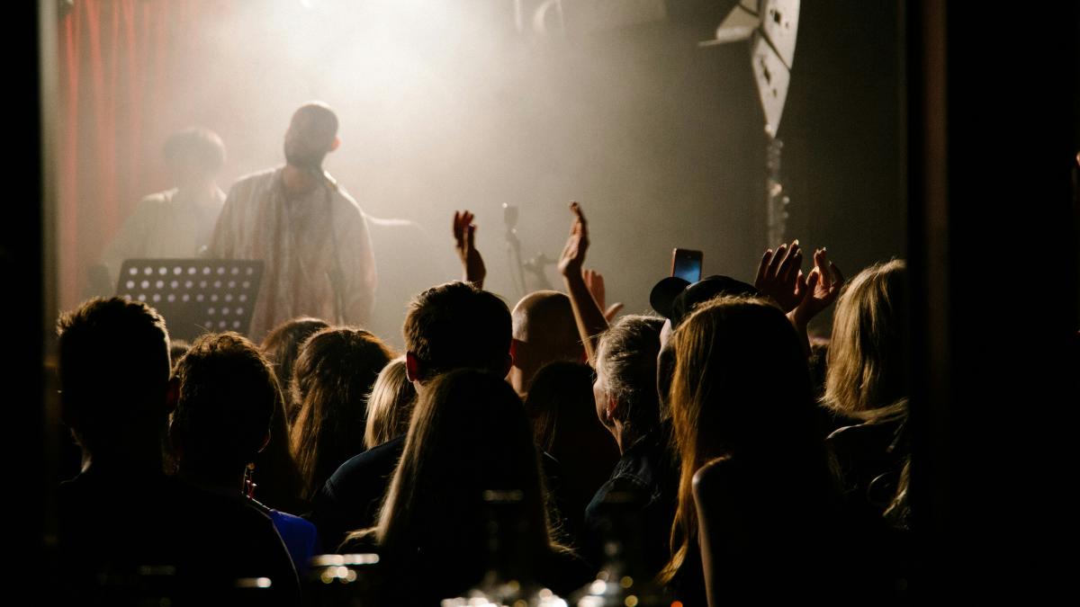 a group of people in front of a stage with a person on it
