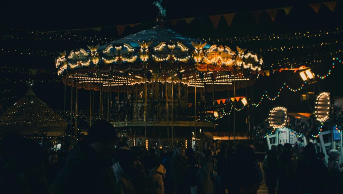 a crowd of people standing around a merry go round