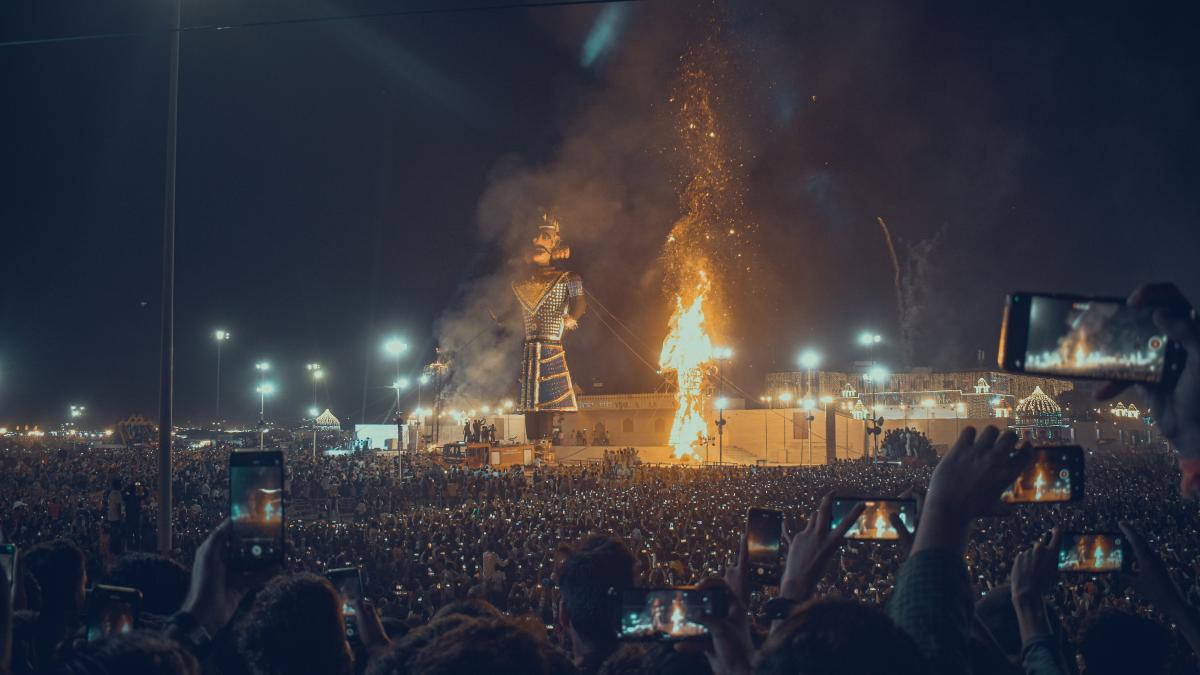 a large crowd of people watching a stage with a large fire