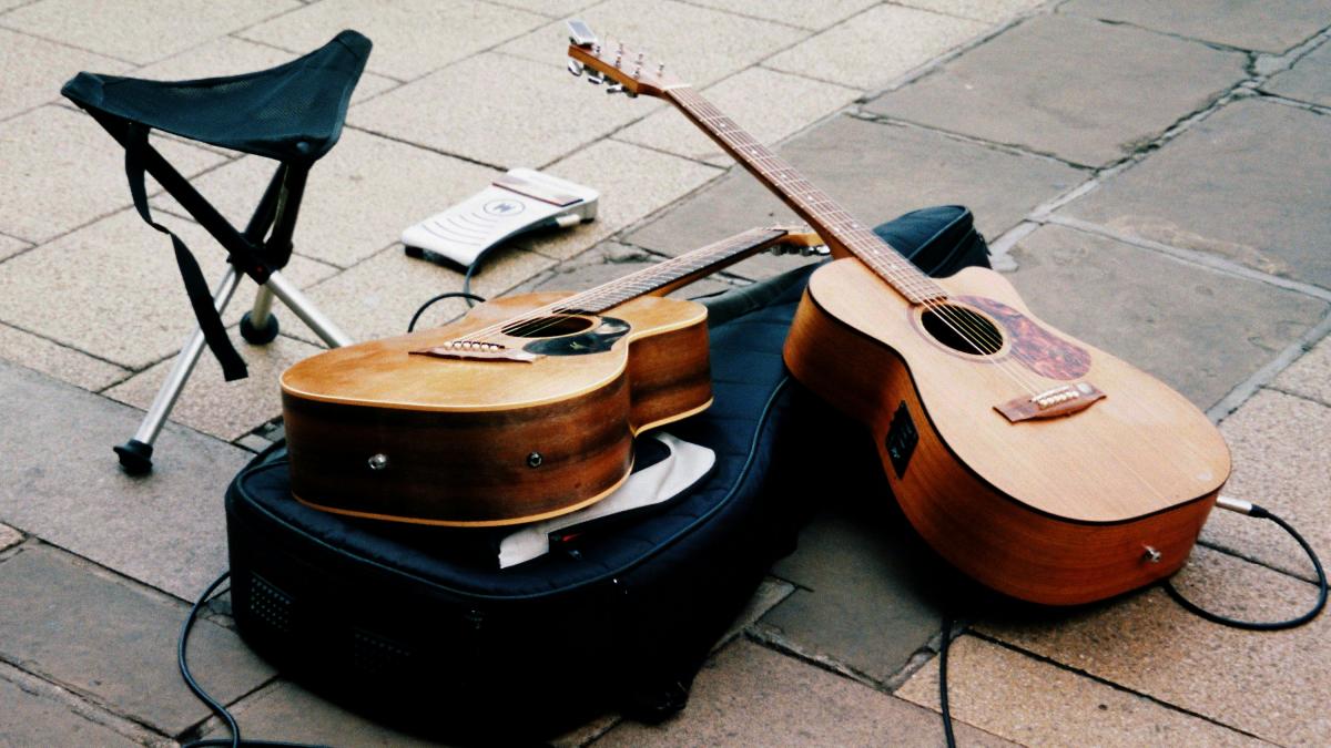 a guitar and a chair on a sidewalk