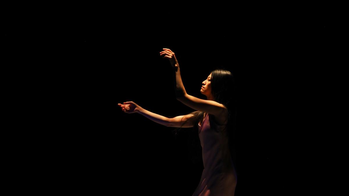 a woman in a purple dress is holding her hand up