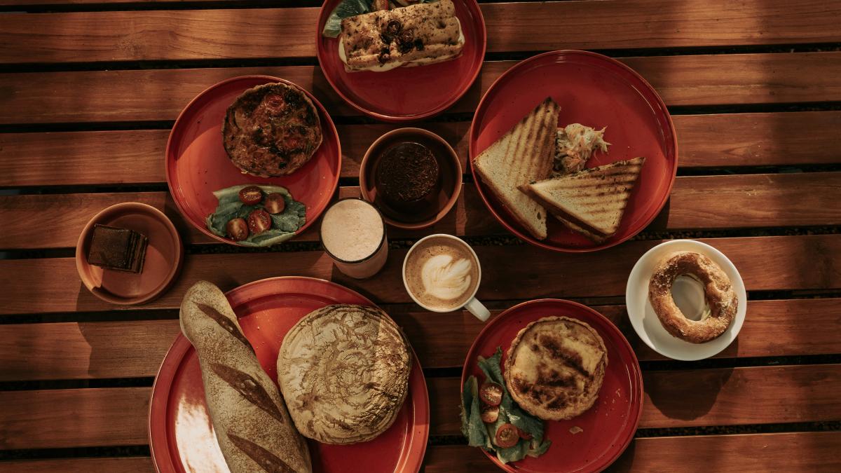a wooden table topped with plates of food