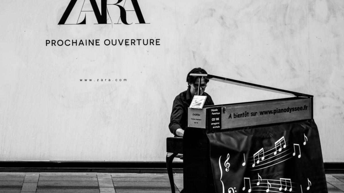 Zara Prochaine Ouverture sign near person sitting