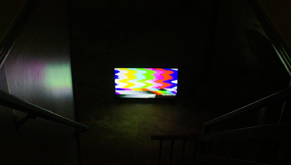 black flat screen tv turned on displaying soccer game
