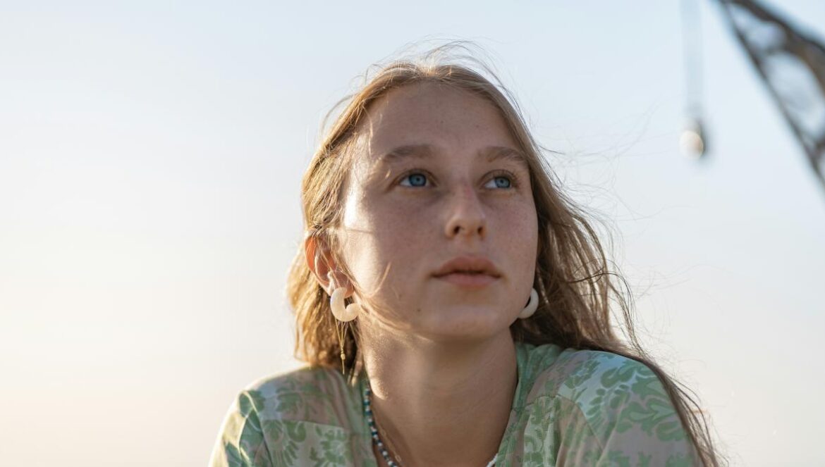 girl in green and white floral shirt
