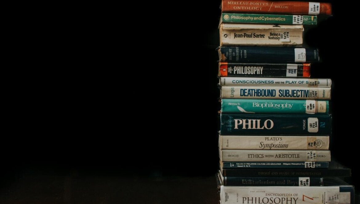 a stack of books sitting on top of a wooden table