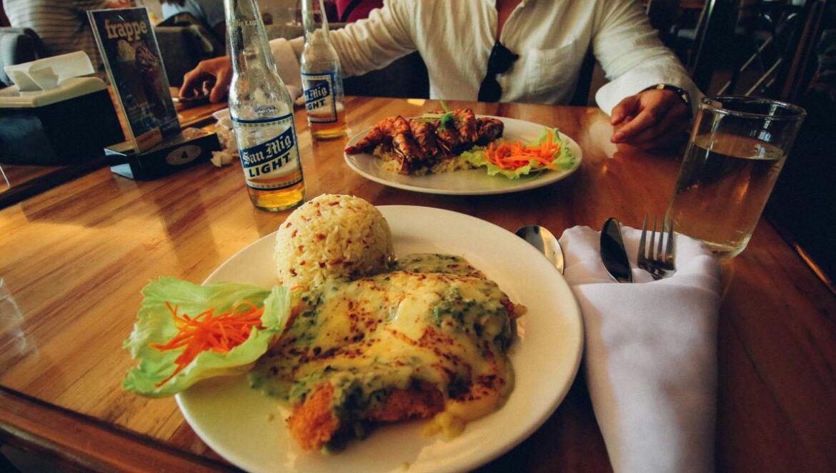 a person sitting at a table with a plate of food