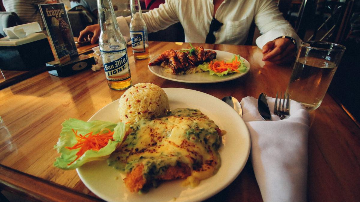 a person sitting at a table with a plate of food