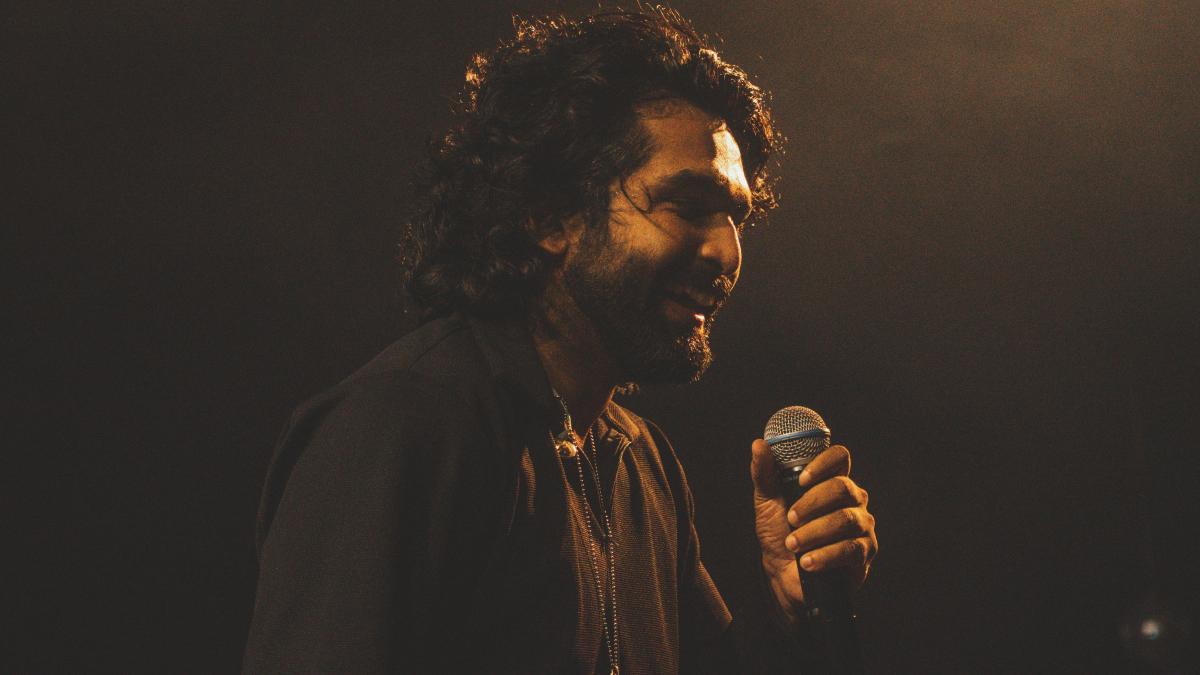 a man with long hair holding a microphone