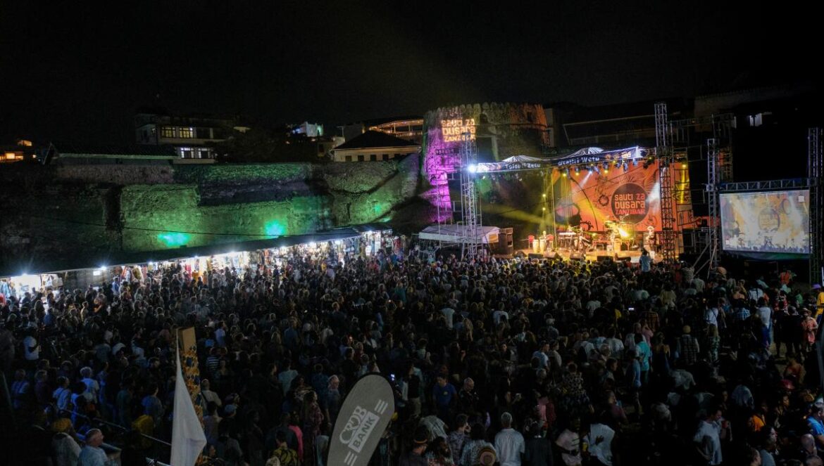 a crowd of people standing around a stage at night