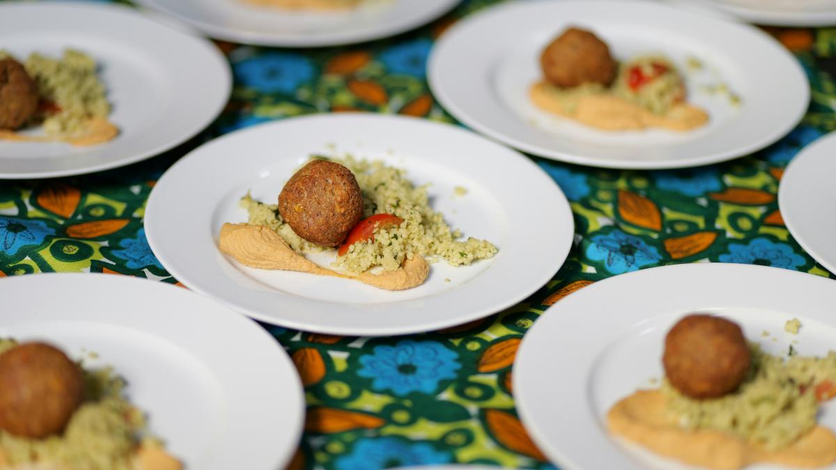 a table topped with white plates filled with food