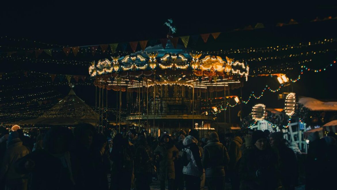 a crowd of people standing around a merry go round